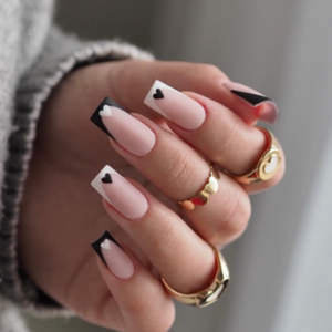 Close-up of beautifully designed nails with a mix of black and white french tips with black & white hearts