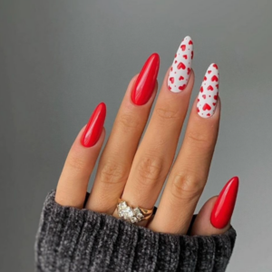 Close-up of beautifully designed Valentine’s Day nails featuring with pink; ring and thump in red and two fingers white nail color with red hearts