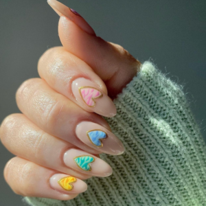 Close-up of beautifully designed Valentine’s Day nails featuring heart on each finger with different color