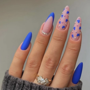 Close-up of beautifully designed Valentine’s Day nails featuring mixture of blue, blue french tips and blue heart with diamond