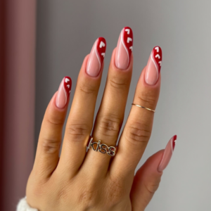 Close-up of beautifully designed Valentine’s Day nails featuring red and white line and white hearts designs