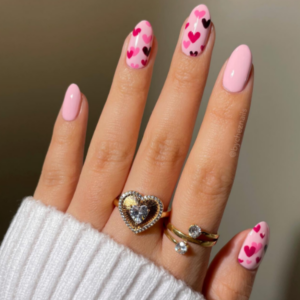 Close-up of beautifully designed Valentine’s Day nails featuring pink nails with red, baabypink and purple hearts design