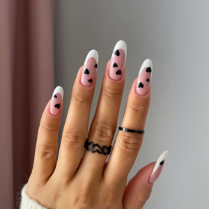 Close-up of beautifully designed Valentine’s Day nails featuring white french tips with black hearts