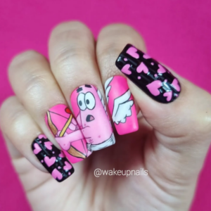 Close-up of beautifully designed Valentine’s Day nails featuring patrick from Sponsbob square pants who is cupid