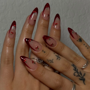 Close-up of beautifully designed Valentine’s Day nails featuring red french tips with heart design in red and glitter