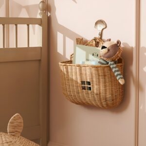 Vertical toy storage featuring hanging wall baskets filled with plush toys and books, installed at a child's height for easy reach.