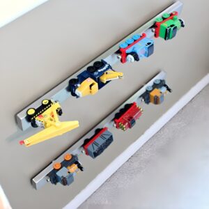 Magnetic strips mounted on a wall, neatly holding small metal toy cars for an organized and unique display.