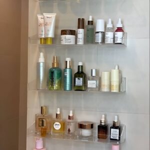 Wall-mounted acrylic ledges for displaying and storing makeup essentials stylishly.