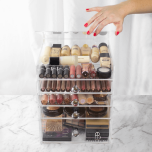 Clear acrylic makeup organizer with multiple drawers for storing cosmetics neatly on a vanity.