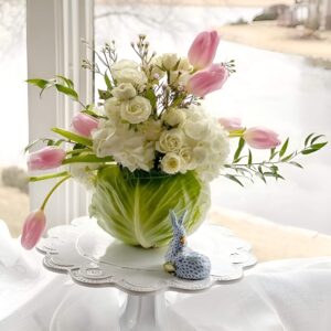 Unique Easter centerpiece featuring a hollowed-out cabbage as a vase, filled with daffodils, tulips, and hydrangeas for a fresh spring display.