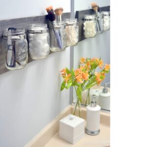 Decorative jars storing cotton swabs, bath salts, and small toiletries stylishly.