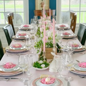  An Easter table bursting with colorful flowers, floral-printed tableware, and scattered flower petals for a vibrant spring-inspired setting.