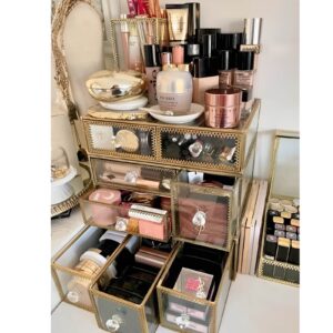 Elegant glass storage containers for organizing beauty products on a vanity.