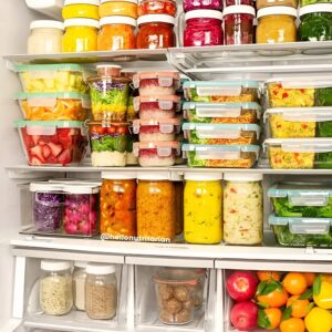 Mason jars filled with prepped meals and salads for an organized fridge.