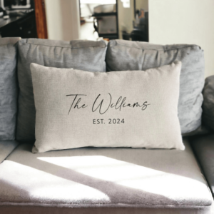 A soft, personalized throw pillow embroidered with initials on a couch.