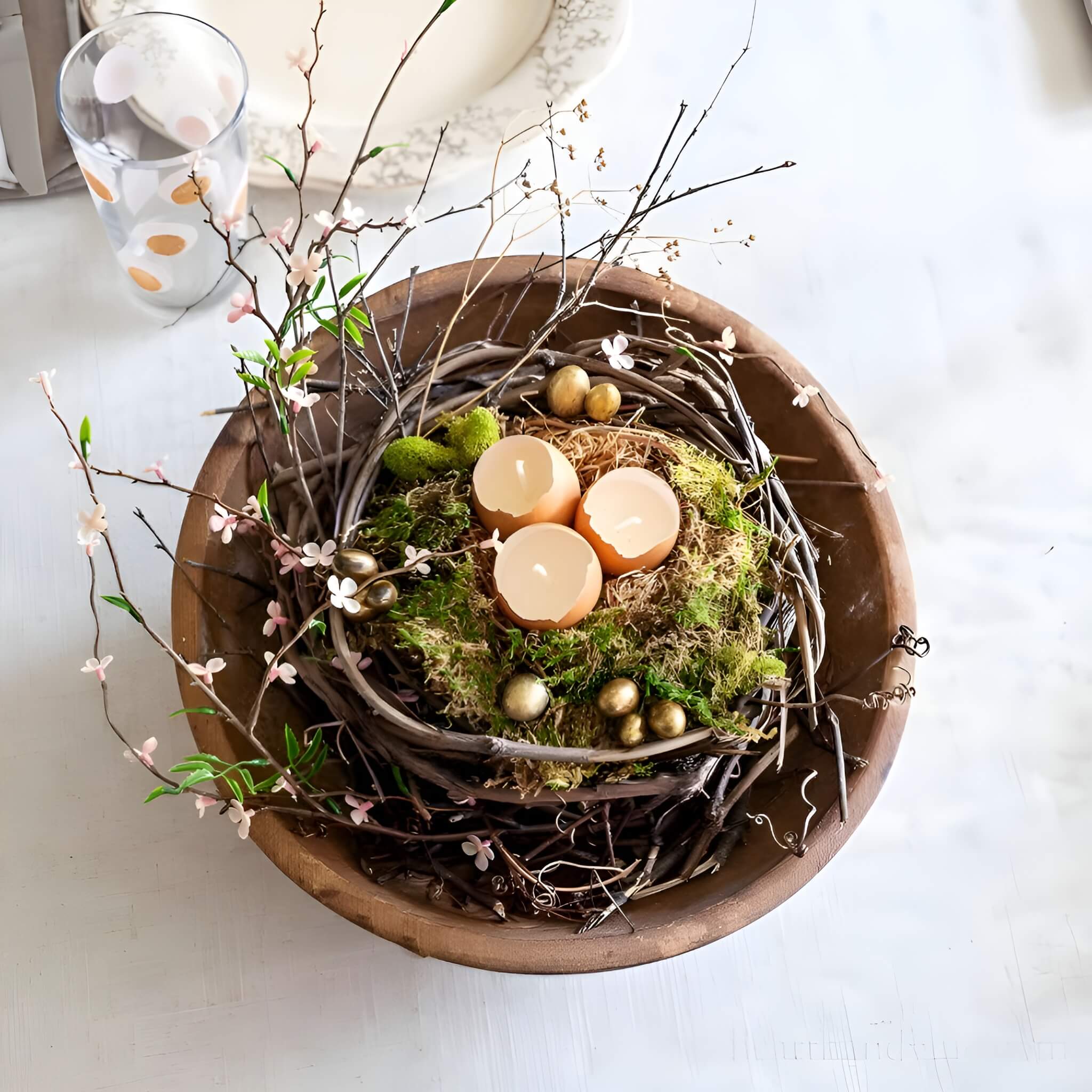 Rustic bird’s nest Easter centerpiece filled with speckled eggs, feathers, delicate blooms, and a small bird figurine for a natural look.