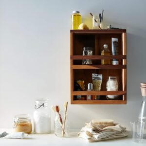 A repurposed spice rack used as a toiletry holder for small bathroom products.