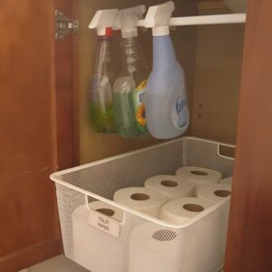 A tension rod installed under the sink to hang spray bottles and create additional storage space.