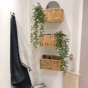 A wall-mounted basket storing toiletries and hand towels to free up counter space.